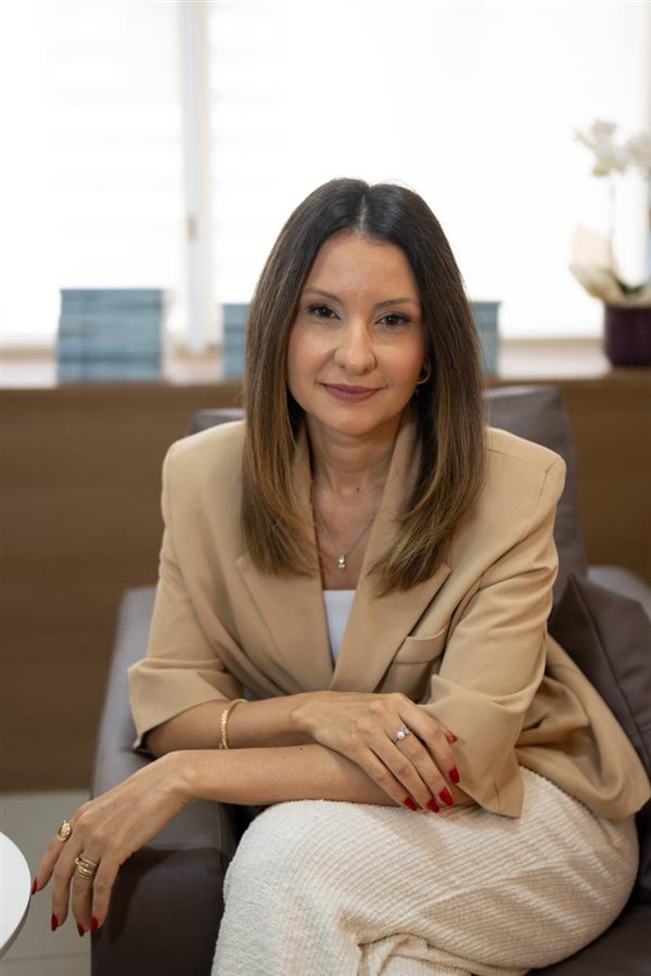 Amanda Hipólito, psicóloga clínica, sorrindo em seu consultório